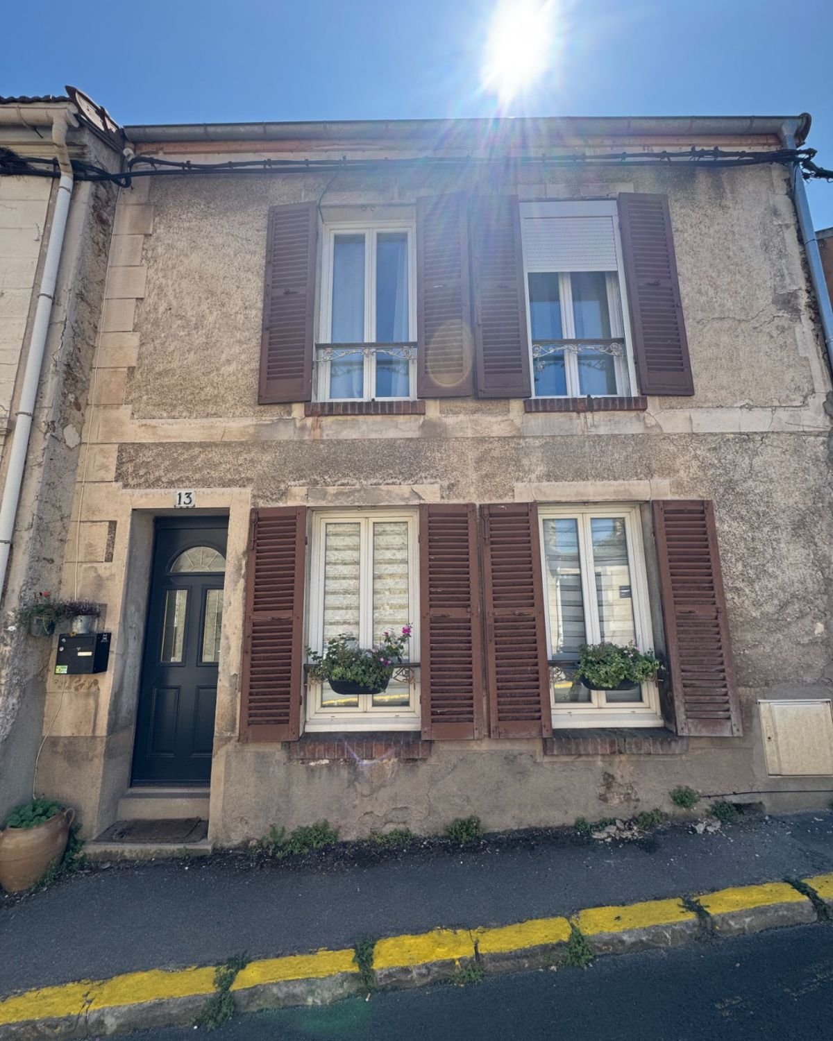 Avant — façade en pierre, volets marron