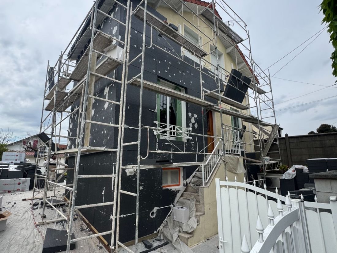 Panneaux isolants posés sur une façade, échafaudage en place